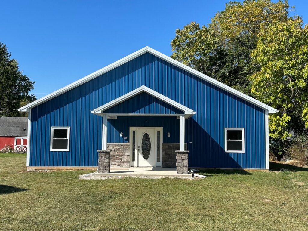 A blue barn with white siding and a white door captured in a photo